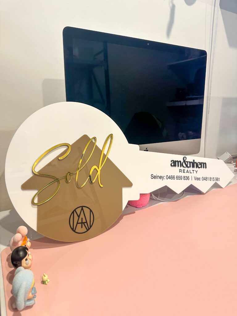 A custom acrylic key sign with a logo, designed for realtors, featuring a personalized touch.