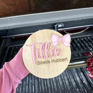 A custom, handcrafted, baby announcement plaque in a bow theme, made from layered acrylic, with a personal touch.