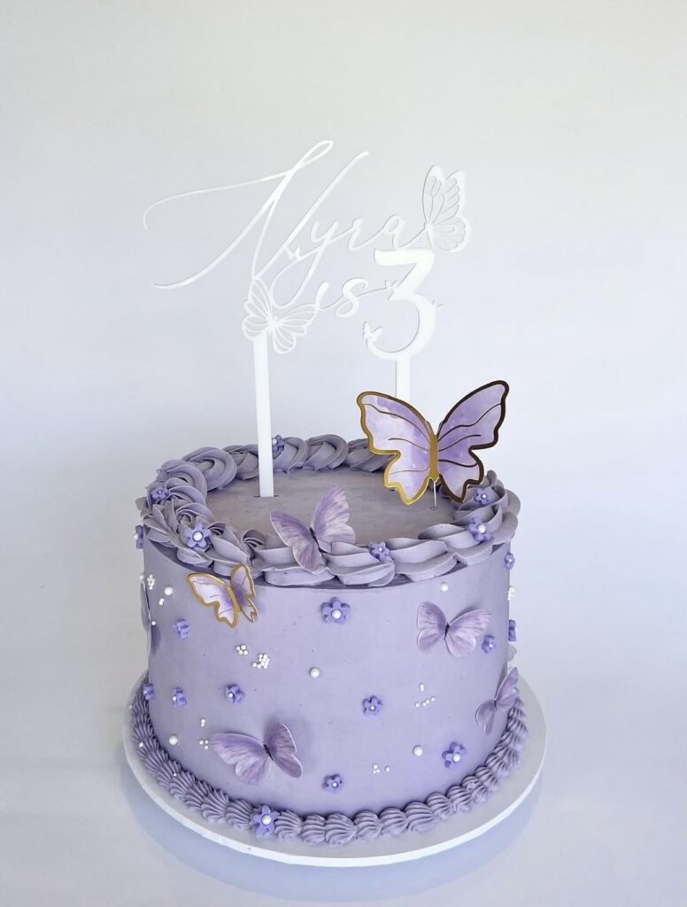 acrylic cake topper with minimalist butterfly design, custom made for a special occasion.