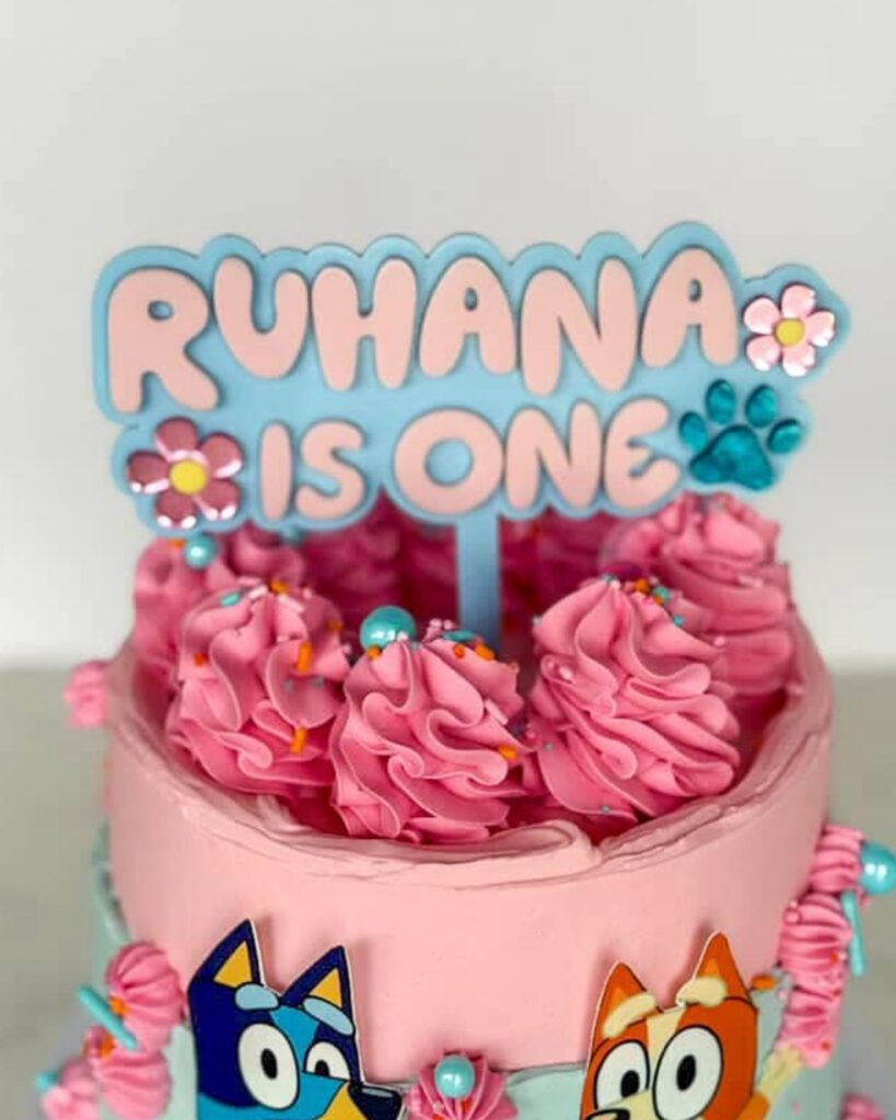 layered acrylic Bluey cake topper with mirrored finish, featuring Daisy and paw prints, ready for personalisation.