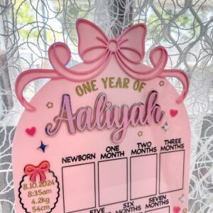 Acrylic photo board with a bow theme, personalised with a name, ideal for capturing a child's first year milestones.