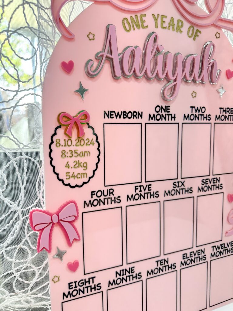 acrylic photo board with a bow theme, ready for personalisation, for a first year baby photo display. Personalised.