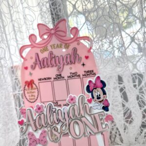 acrylic photo board with a bow theme, personalised with a baby's name and first year photos.