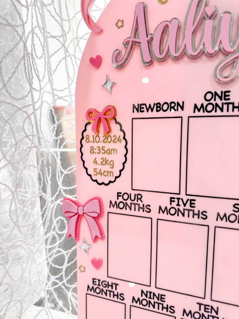 acrylic photo board with bow theme, personalised with baby's name and first year details. A keepsake for a special first.