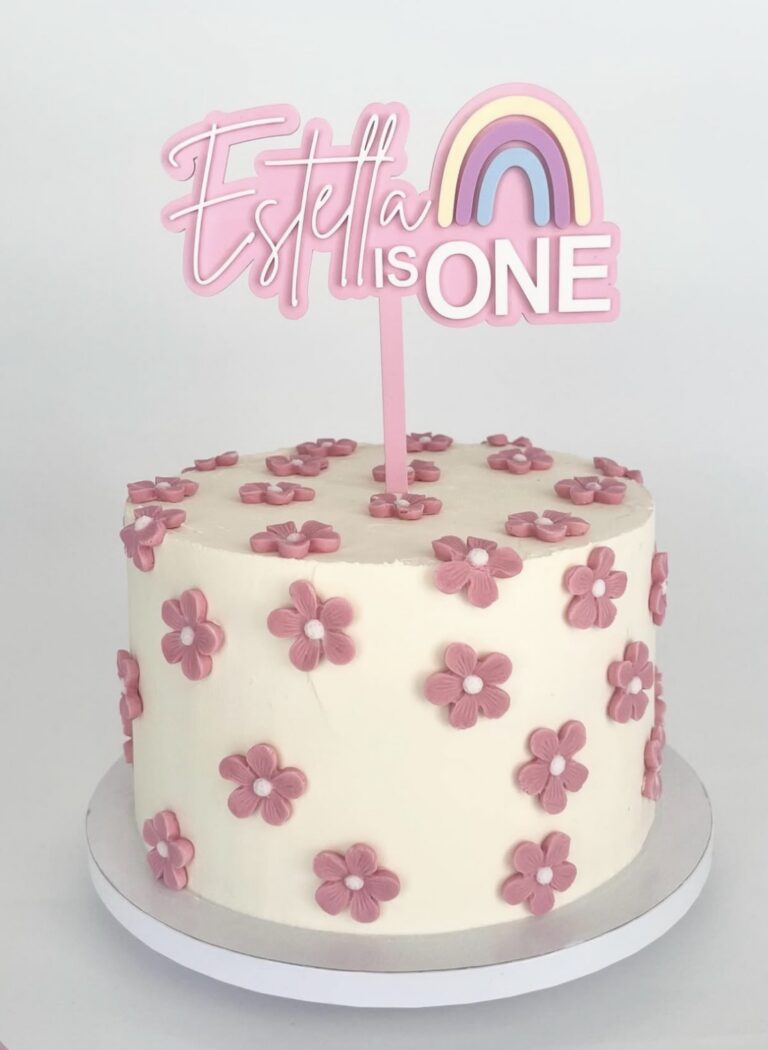 Personalised rainbow cake topper with custom name and age, crafted from layered acrylic in a glossy finish.