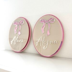 A custom, triple-layered acrylic name plaque featuring a bow design, ready for personalisation.