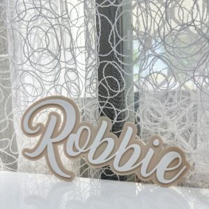 A custom, handcrafted, layered acrylic name door sign for kids, personalised with a child's name in a bold, cursive font.