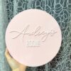 A custom, handcrafted, acrylic door sign for kids' rooms and nurseries, featuring a child's name in a bold, cursive font.