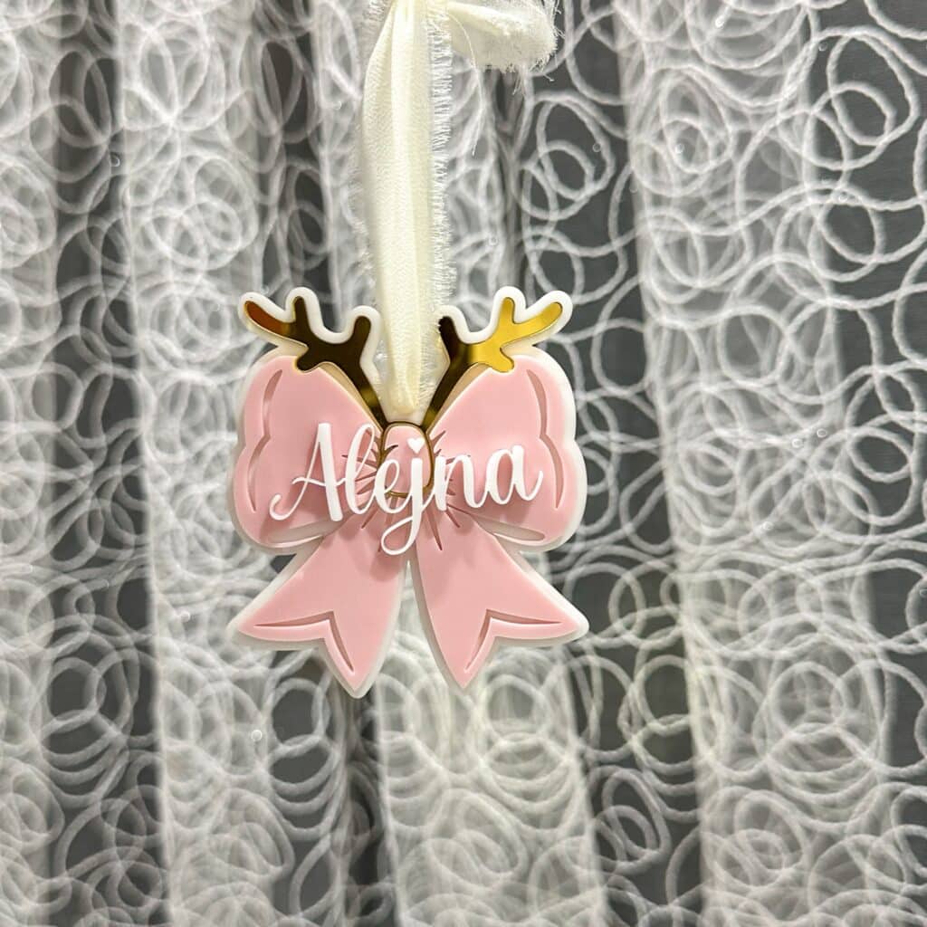 A custom, handcrafted, layered acrylic bow Christmas ornament, ready for personalisation. Personalised with a name, this.
