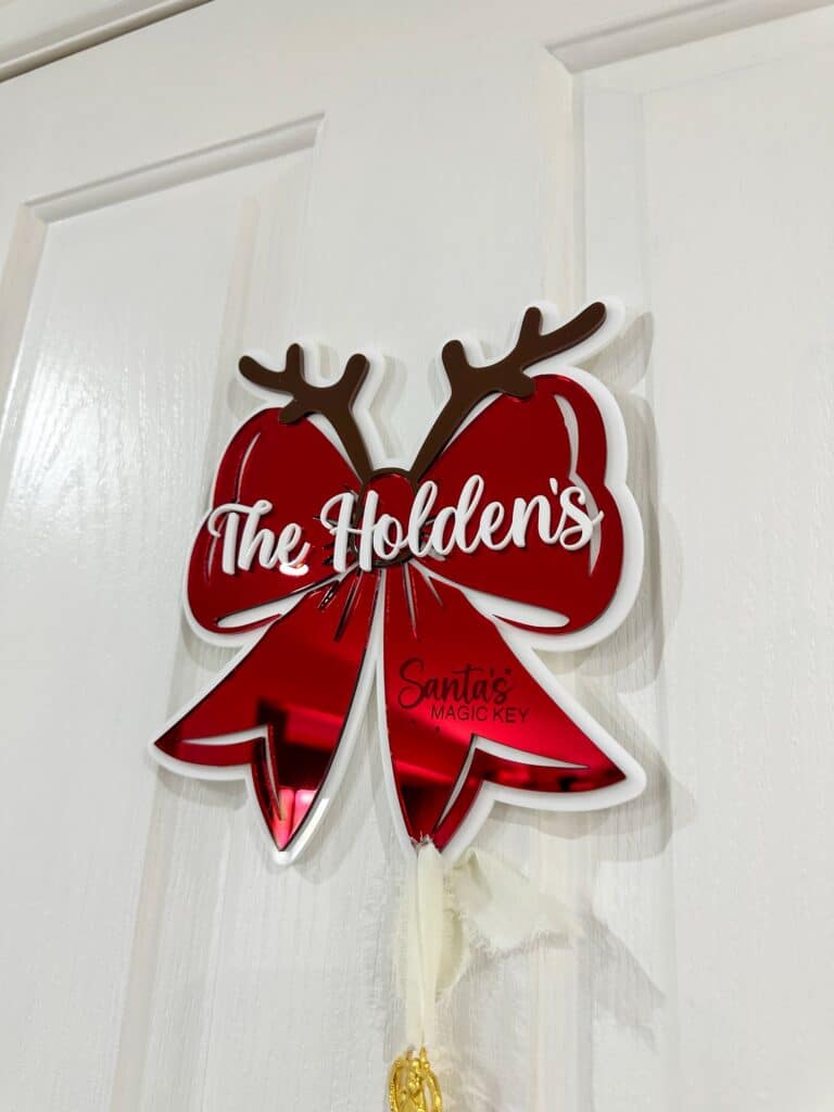 Personalised Christmas Bow Door Hanger – Santa’s Key, made from layered acrylic with a mirrored finish.