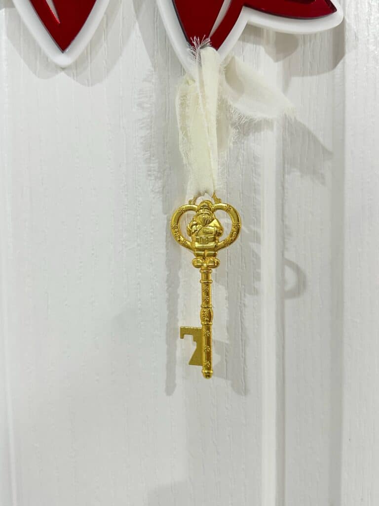 Personalised Christmas Bow Door Hanger – Santa’s Key, made from layered acrylic with a mirrored finish.