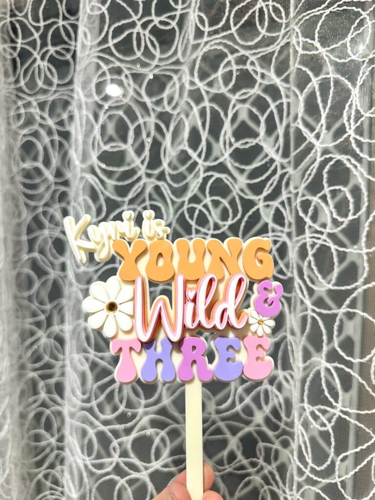 Personalised acrylic name sign in script style photographed on a plain background.
