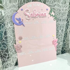 Clear personalised acrylic name plaque photographed on a neutral background.
