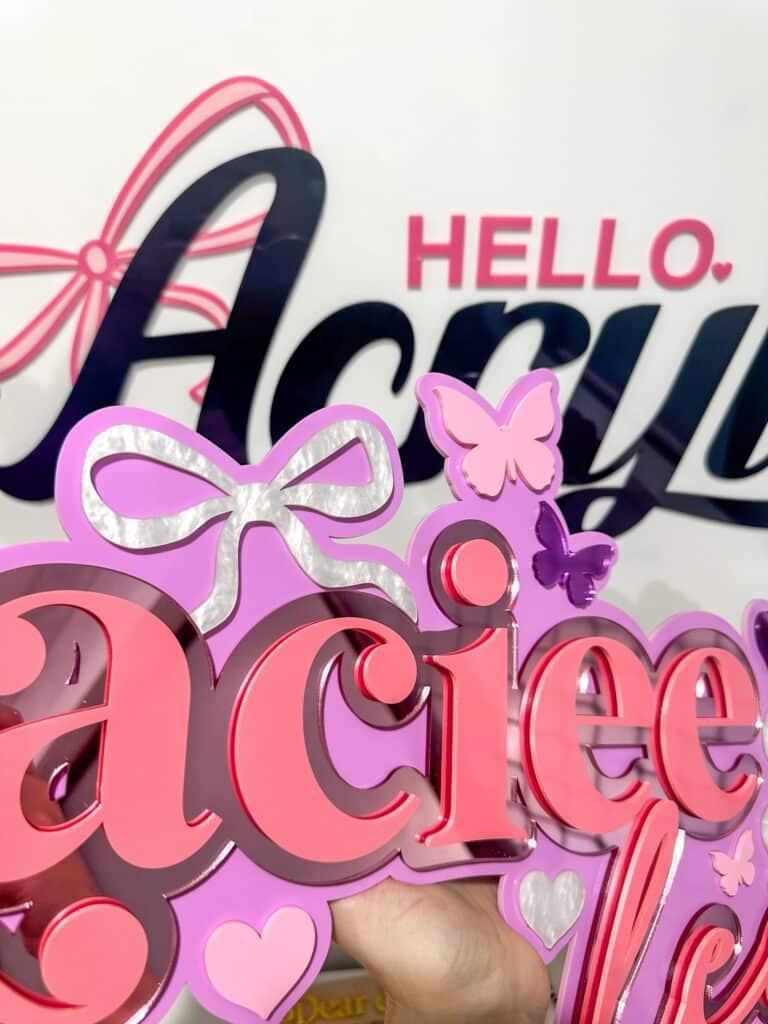Clear personalised acrylic name plaque with engraved lettering on a neutral background.