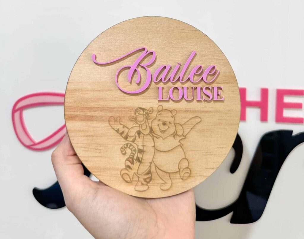 Engraved plywood plaque with raised acrylic lettering reading 'Bailee Louise' featuring Winnie the Pooh and Tigger.