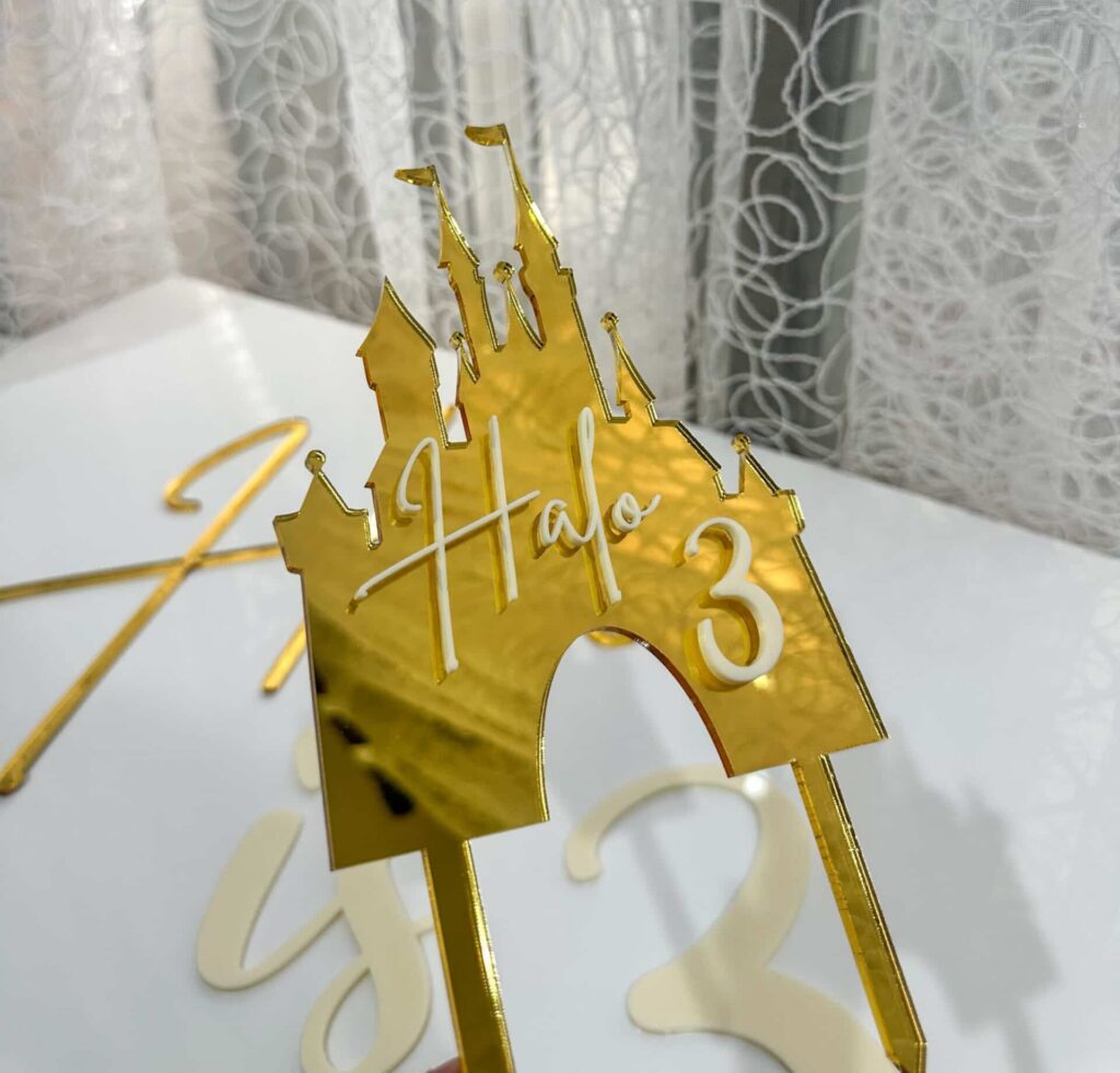 Acrylic Disney castle cake topper personalised with a princess name, in a gold mirror finish.