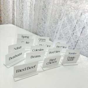 Acrylic food labels, custom catering signs, made from layered acrylic, with a glossy finish, for labelling dishes at events.